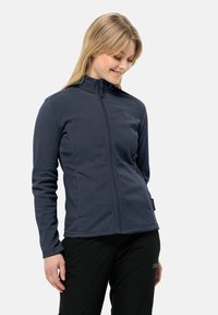 Giacca in pile blu navy con colletto alto e zip a tutta lunghezza, caratterizzata da un logo sul petto e cuciture piatte per una maggiore durata.