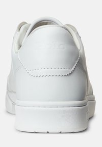 Vit lädersneaker bakifrån med präglad "Polo"-branding på hälfliken och en texturerad gummisula.