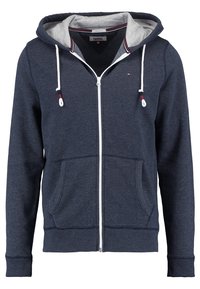 Marinblå zip-tröja i mjukt tyg med en ljusgrå insida, som har två framfickor, dragsko i huva och ribbad mudd.