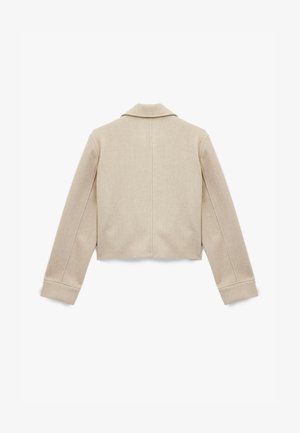 Chaqueta corta beige de tela suave con cuello de muesca, con mangas largas y costuras visibles en la parte posterior. Textura lisa sin patrones.