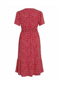 Robe rouge longueur genou avec manches courtes, motif de points blancs irréguliers, taille cintrée et ourlet à volants, vue de dos.