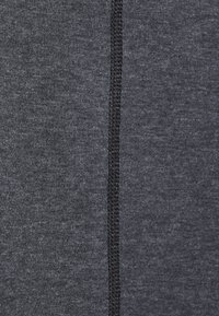 Tejido atlético gris oscuro con una textura suave, que presenta una costura negra a lo largo de una costura vertical para añadir detalle.