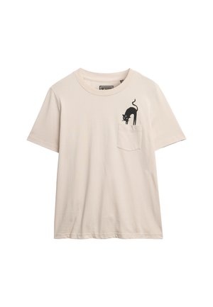 T-shirt en coton beige pâle à manches courtes avec un graphique de chat noir sur la poche poitrine gauche. Design classique à col rond.