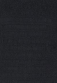 Tessuto nero con un design texturizzato e arricciato, caratterizzato da pieghe verticali e orizzontali. La superficie appare morbida e leggermente elastica.