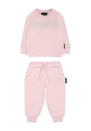 Felpa rosa e pantaloni jogger coordinati realizzati in un morbido tessuto, caratterizzati da polsini a coste, tasche e un logo discreto su entrambi i capi.
