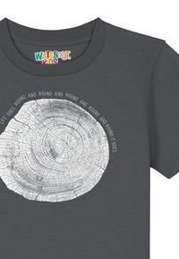 Grijze t-shirt met een ronde boomringafbeelding in het wit, met de tekst "Het leven draait rond en rond en rond en rond gaat het" eromheen.