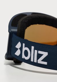 Kék sígoggles széles, rugalmas pánttal, fehér márkás logóval, barna szűrővel és texturált párnázással a keret belső oldalán.