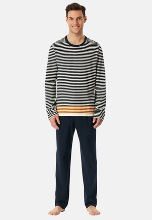 Raidallinen pitkähiha shirt tummansininen, kerma ja oranssi, yhdistettynä yksivärisiin tummansinihin housuihin. Pehmeä kangas, rento malli ja pyöreä pääntie.