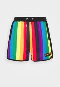 Shorts courts à rayures arc-en-ciel avec taille élastique noire et cordon, présentant un patch de la marque ellesse sur le côté inférieur droit.