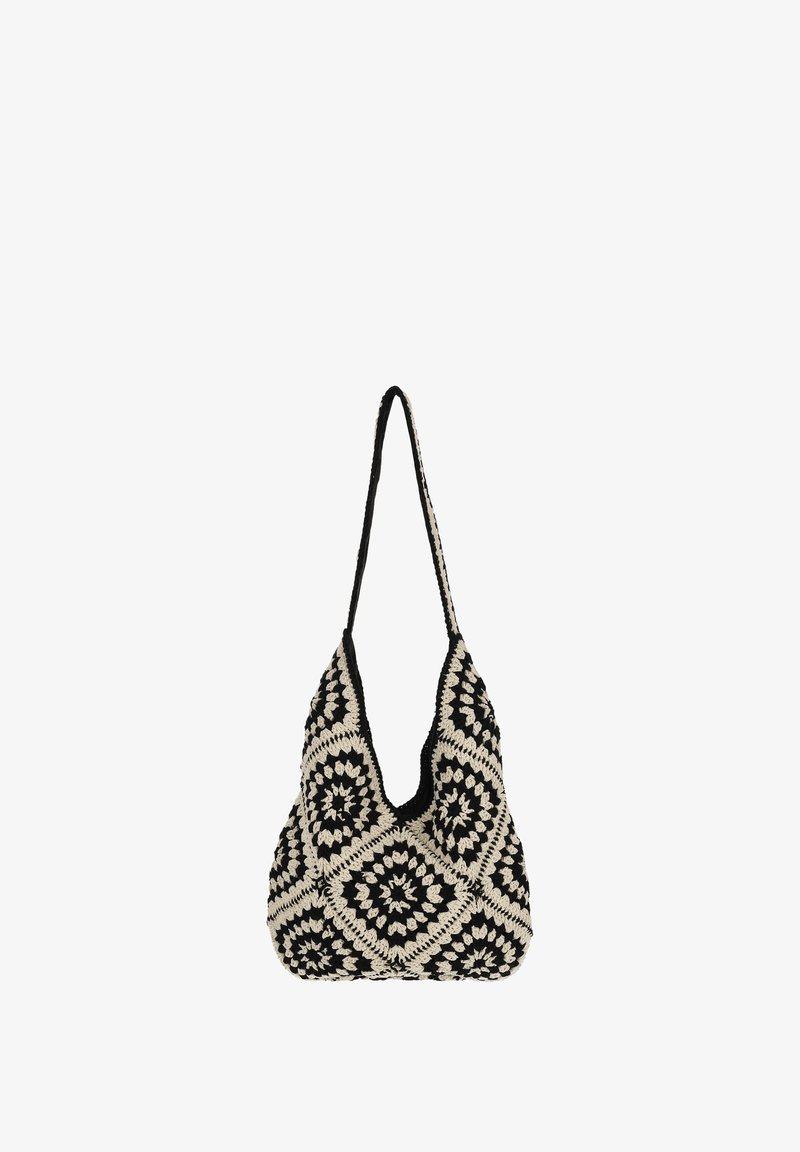 Geantă croșetată alb-negru, cu un model distinctiv de pătrat granny, având o formă adâncă în V și o curea simplă.