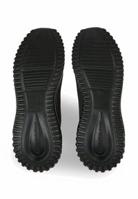 Suole in gomma nera con texture e scanalature per una buona aderenza. Design pulito con il nome del marchio impresso di lato.