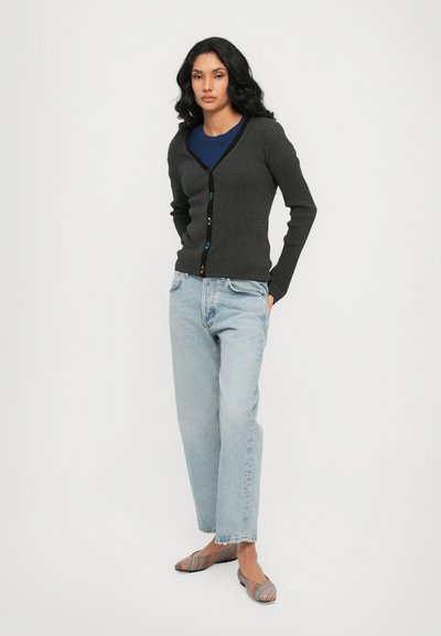 Dark gray ribbed cardigan with a V-neck and colorful buttons, paired with light blue loose jeans and multi-striped flats.