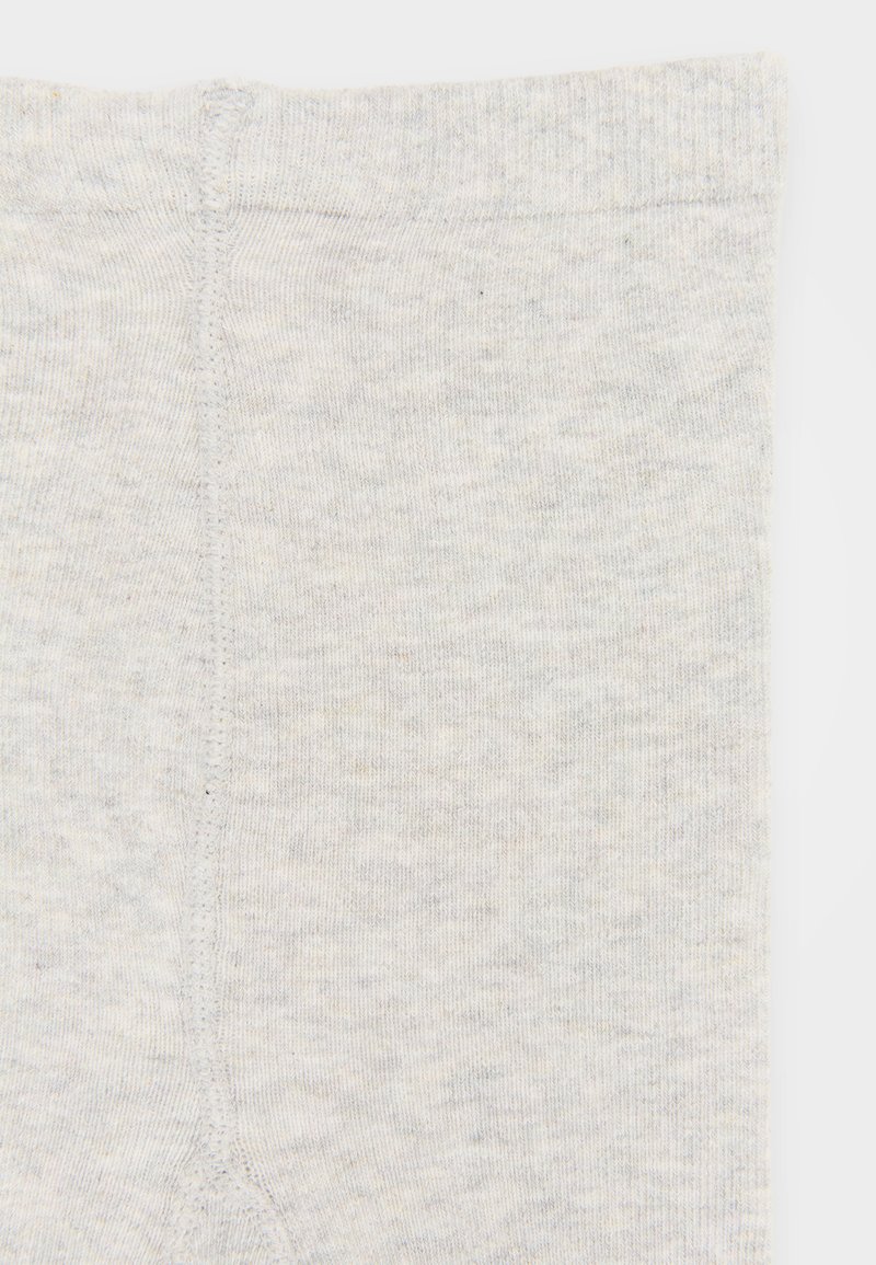 Hellegraue, gerippte Leggings mit weicher Textur. Verfügt über einen schlichten Bund und eine Mittelnaht, die vertikal über den Rücken verläuft.