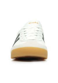 Sneaker atletica bianca con strisce nere, con lacci frontali, logo Gola in oro sulla linguetta e suola in gomma. Parte superiore in pelle liscia con dettagli in camoscio.