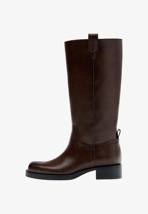 Stivale in pelle marrone scuro fino al ginocchio con tacco basso a blocco, linguetta di tiraggio in alto e sul retro, e punta arrotondata, mostrato di profilo laterale.