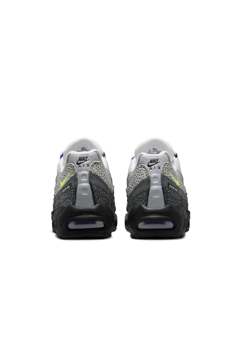 Zapatillas Nike Air con un diseño en gris y negro, parte superior de malla, amortiguación de aire visible y un acento neón en el talón.