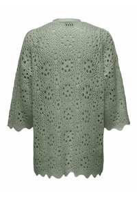 Groene gebreide cardigan met een bloemig haakpatroon, korte mouwen en een gegolfde zoom, met opengewerkte details door de stof heen.