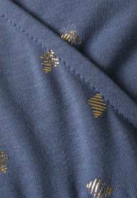 Tecido azul com uma textura suave, apresentando padrões geométricos dourados e um delicado detalhe de nervuras. Overall liso, com um leve brilho devido aos destaques.