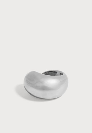 Glänzender silberner massiver, gebogener Ring mit glatter Oberfläche auf einfachem hellem Hintergrund.