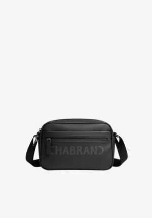 Sac bandoulière noir rectangulaire avec sangle réglable, poche avant zippée et nom de la marque discrètement embossé sur une surface lisse.
