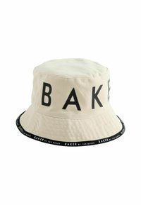 Beige Bucket Hat aus Baumwolle mit einem schwarzen Band, das den wiederholten Text "BAKER" zeigt. Kurzer Rand und glatte Textur. Schlichtes Design.