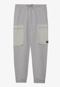 Šedé tepláky s regulovatelným pasem na tkaničku, dvěma velkými světle šedými kapsami na zip a pružnými manžetami. Materiál s fleecovou strukturou, neformální design.