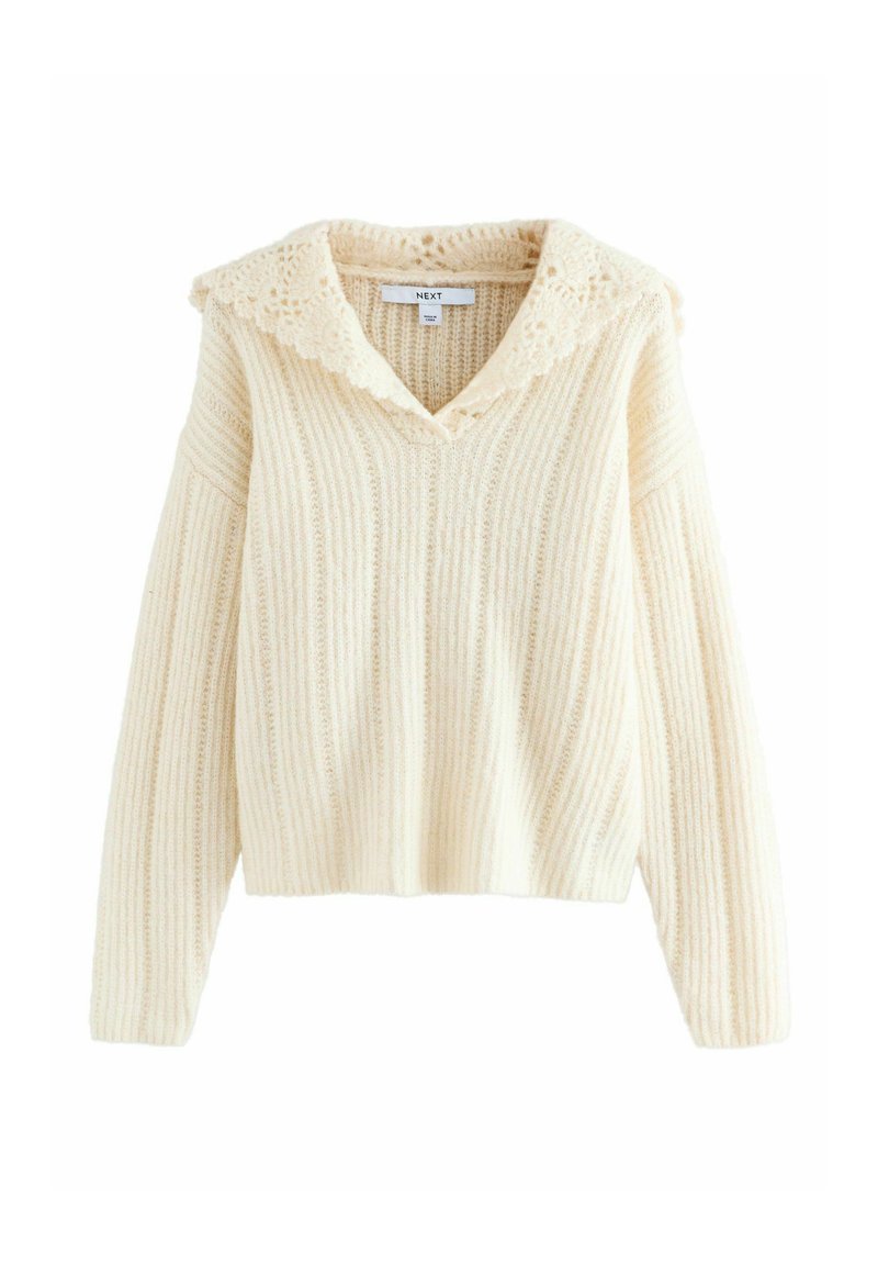 Cremefarvet sweater med en hæklede blondekrave, ribbet tekstur og lange ærmer. Kort design. Mærket er synligt inde i halsudskæringen.