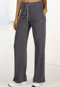 Gray ribbed wide-leg pants with an elastic waist and drawstring, featuring side pockets and a logo detail on the front.