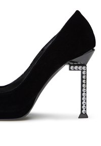 Scarpa con tacco alto in suede nero, dotata di un tacco geometrico unico con rhinestone trasparenti lungo un lato e una finitura nera lucida.