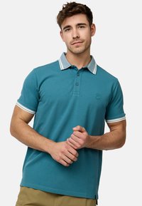 Teal polo shirt med en 3-knaps placket, med en lys blå og hvid stribet krave og ærmebånd. Blød, glat tekstur.