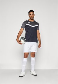 Herrenfußballtrikot mit einem dunkelgrauen und weißen Trikot, weißen Shorts, weißen Socken und einem schwarz-weißen Fußball, mit einem Logo auf dem Shirt.