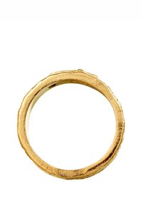 Guldring med en texturerad, ojämn yta som har en naturlig, organisk form. Insidan är slät, vilket står i kontrast till den yttre ytan.