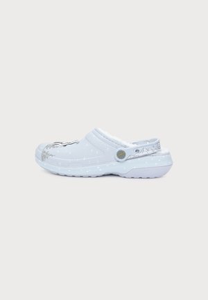 Sabot Crocs bleu clair avec motif moucheté blanc, bride de talon réglable et doublure intérieure blanche et moelleuse.
