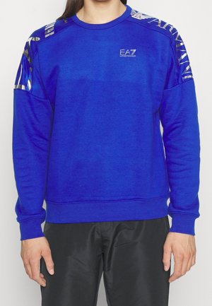 Sweatshirt bleu à manches longues, col rond et finition texturée. Présente des accents métalliques sur les épaules et un logo sur la poitrine.