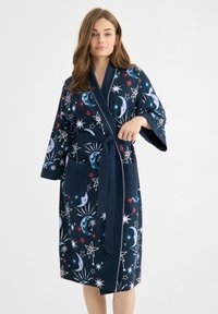 Marinblå morgonrock med himmelska mönster, som har månar och stjärnor. Tillverkad av mjukt tyg, har den vida ärmar, knytmidja och två fickor.