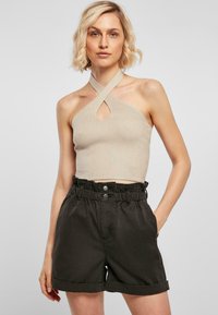 Béžový žebrovaný crop top s halter krkem a otvorem na klíč, doplněný tmavě zelenými šortkami s elastickým pasem a ohrnutými manžetami.