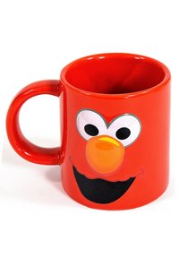 Mug ceramico rosso con il volto di un personaggio dei cartoni animati, con grandi occhi, un naso arancione e un sorriso nero. Finitura liscia e forma rotonda.