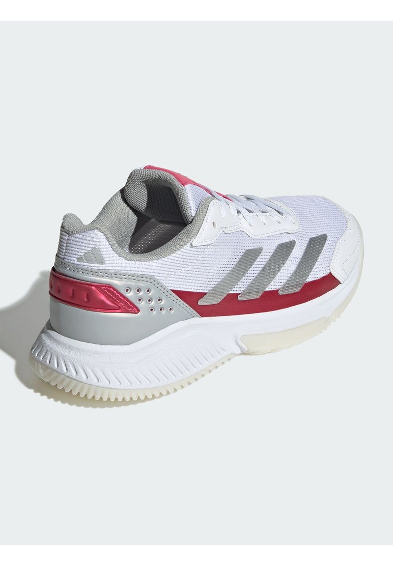 Zapatilla deportiva blanca con un upper texturizado, detalles en gris y un panel sintético rojo. Talón reforzado con una suela blanca estriada.