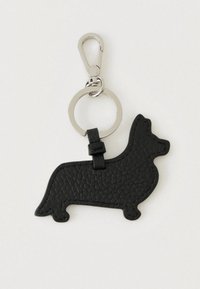 Μαύρο δερμάτινο μπρελόκ με υφή, σε σχήμα σκύλου κορги, με ασημένιο μεταλλικό δαχτυλίδι και κούμπωμα σε ανοιχτό φόντο.