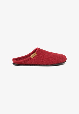 Red slip-on slipper with soft textured upper and flat black sole, featuring a small brown brand tag on the side.