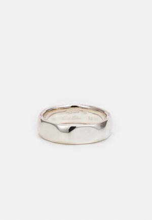 Silver ring med en slät, rundad design. Har en vågig kant och en polerad yta. Inuti ingraverat med storlek och märkesdetaljer.
