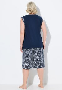 Marineblauw mouwloos topje met bloemenmotief shorts; katoenmateriaal; losse pasvorm; shorts hebben een elastische tailleband en komen tot halverwege de kuit.