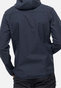 Chaqueta con capucha de color azul marino, confeccionada con un tejido suave y texturizado. Presenta un ajuste entallado y sutilezas de costura a lo largo de las costuras y el dobladillo.