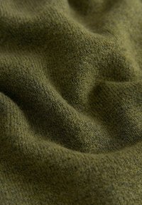 Pletená látka v olivově zelené barvě, s jemným, texturovaným povrchem a subtilním melírováním. Látka vypadá, že je lehce naskládaná a pružná.