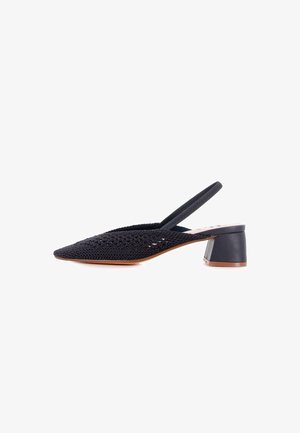 Zapato slingback negro tejido con punta afilada, tacón bajo en bloque y parte superior texturizada. Presenta un acento de piel suave en el tacón.