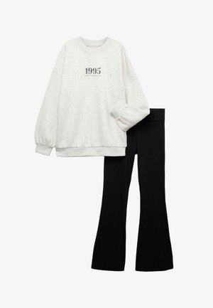 Sweat-shirt gris en coton avec impression "1995" et leggings noirs. Le sweat-shirt présente un col rond et des poignets côtelés ; les leggings sont ajustés.