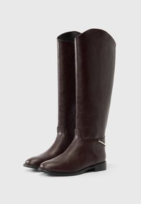 Ψηλές σκούρες καφέ δερμάτινες μπότες με στρογγυλεμένα δάχτυλα, χαμηλά τακούνια και μια μικρή ασημί αγκράφα στο πλάι.