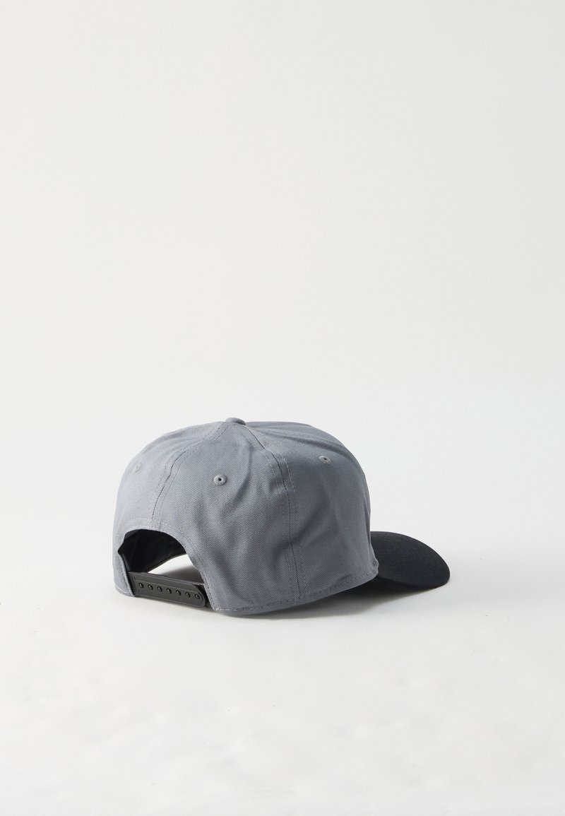 Grau-schwarze Snapback-Kappe, liegend auf der Seite mit sichtbarem verstellbarem Kunststoffriemen vor weißem Hintergrund.