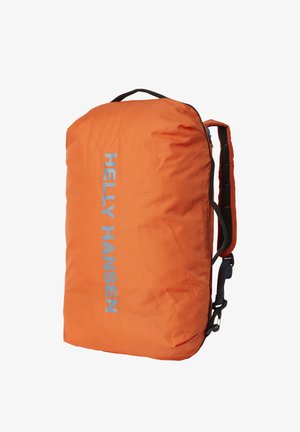 Sac à dos Helly Hansen orange vif avec bretelles rembourrées et logo réfléchissant vertical à l'avant, conçu pour une utilisation en extérieur.