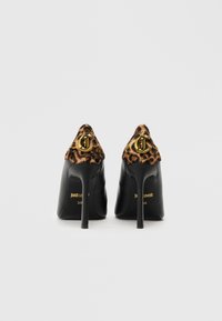Cizme negre cu toc înalt, cu accente de imprimeu leopard, accesorii din aur, vârf ascuțit și toc stiletto elegant, având logo-ul mărcii pe spate.
